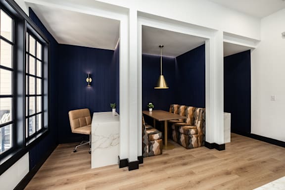 A room with a white table and chairs with a blue wall.