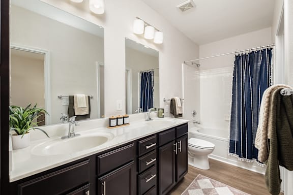 A bathroom with a white sink and a mirror above it.