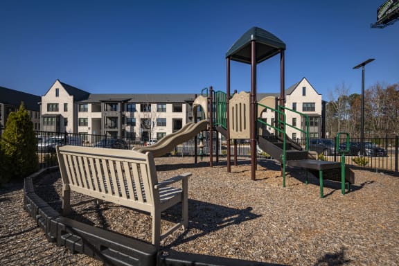 a playground with a slide and a bench in a park
