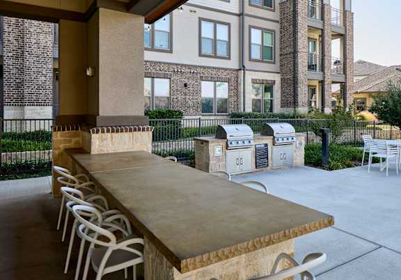A long table with chairs is in front of a building.