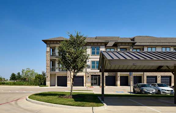 A modern building with a parking lot in front.