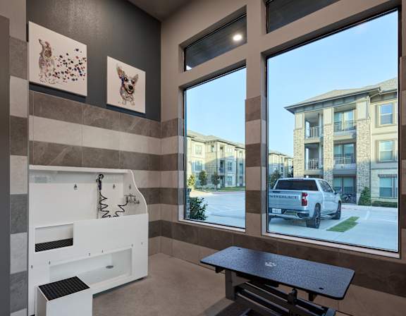 A bathroom with a large window overlooking a street with a white truck.