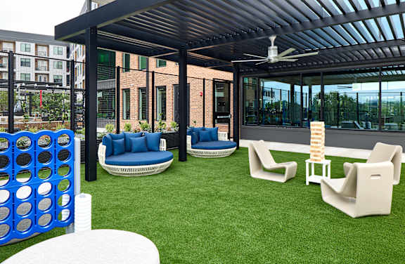 A patio with a white table and blue couches.