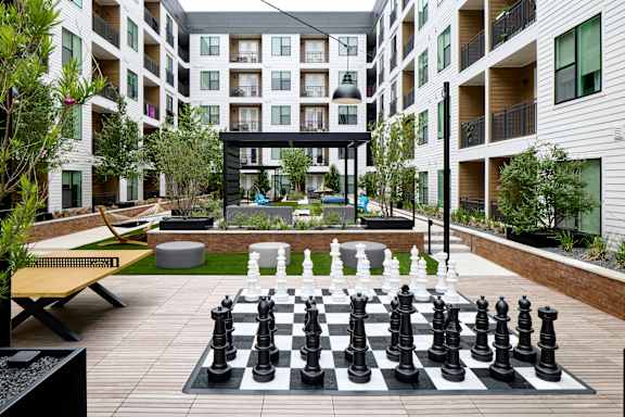 A giant chess board is in the middle of a courtyard.