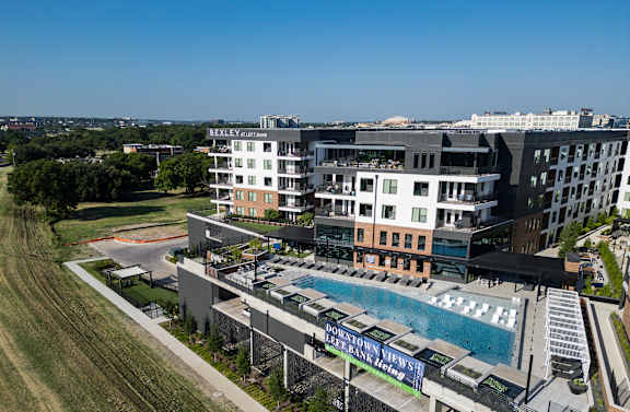 A large building with a pool in front of it.