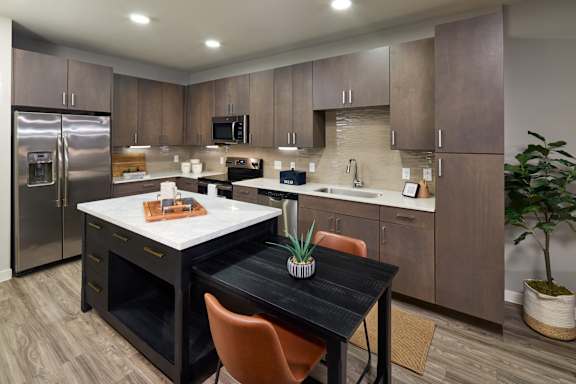 A kitchen with a table and chairs in the middle.