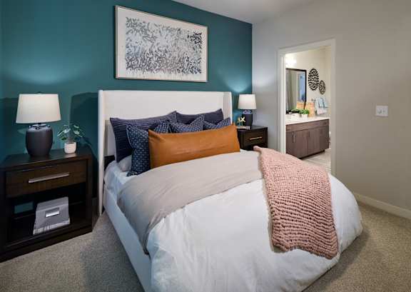 A bedroom with a white bed and a pink blanket.