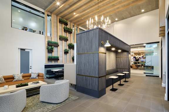 A modern living room with a grey sofa and a wooden ceiling.