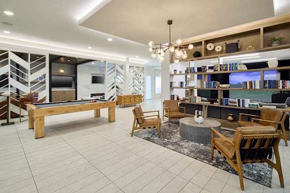 A living room with a pool table and a fireplace.