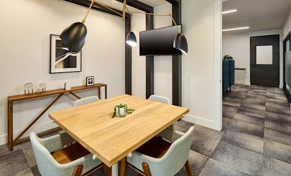 A dining room with a wooden table and chairs.