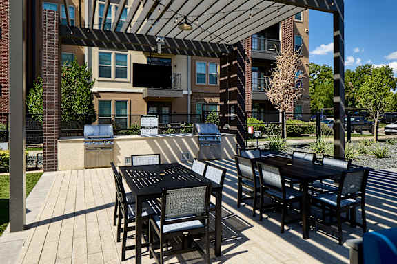A patio with a table and chairs is in front of a building.