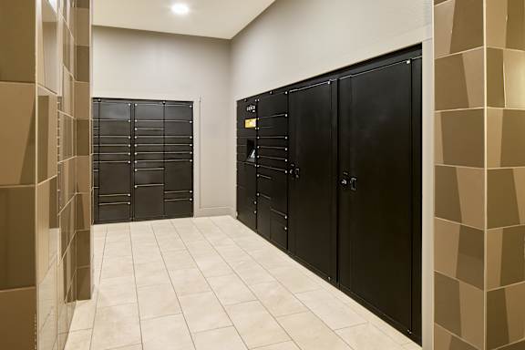 A hallway with black doors and a tiled floor.