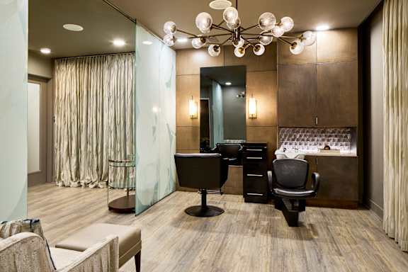 A modern office with a glass wall and a wooden floor.
