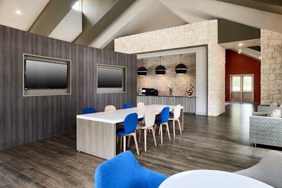 A modern dining room with a white table and blue chairs.
