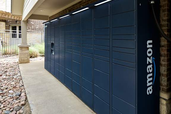 A dark blue Amazon storage unit is closed and has a hose attached to the side.