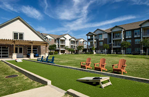 A sunny day at a residential complex with lawn chairs and picnic tables.