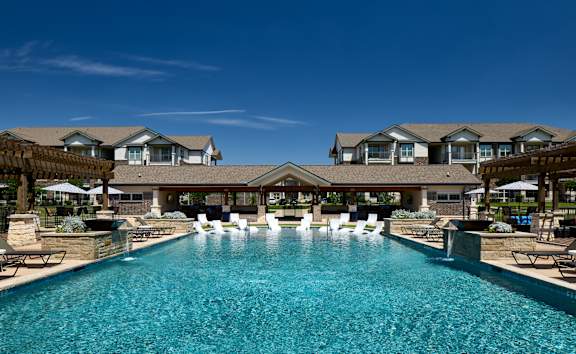 A large swimming pool in front of a resort-style building.