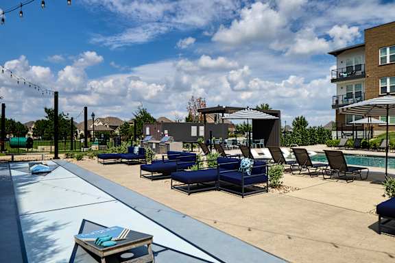 A pool area with lounge chairs and umbrellas.