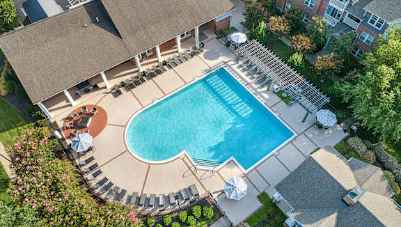 A large swimming pool surrounded by a patio and a deck.