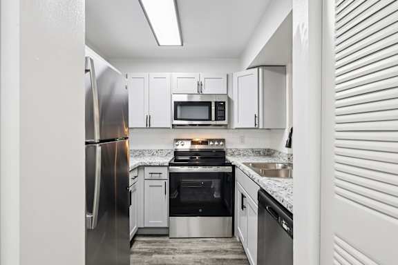 A kitchen with a refrigerator, microwave, oven, and sink. at Lakeside Glen Apartments, Florida