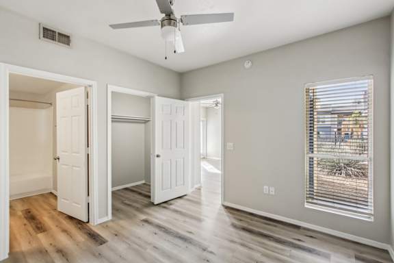 A room with a ceiling fan and a window with blinds at Sweetwater At Metro North Apartments, Arizona