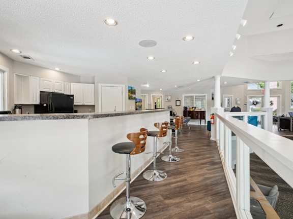 A long white bar with stools and a counter.