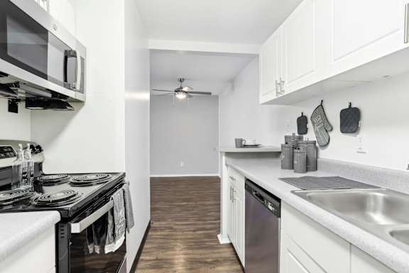 A modern kitchen with white cabinets and a black stove top.at Millennium at Creve Coeur, Creve Coeur, MO, 63141