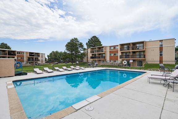 A swimming pool in front of apartment buildings at Broadmoor Springs, Colorado Springs
