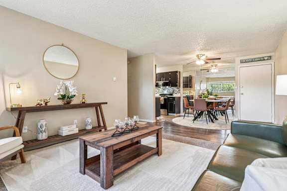 A living room with a wooden coffee table and a mirror on the wall at The Montecito, Colorado Springs