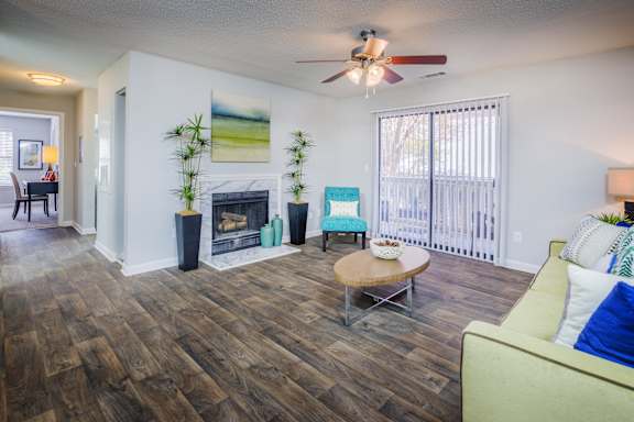 A living room with a fireplace and a ceiling fan at The Pointe at Irving Park, Greensboro, NC, 27408