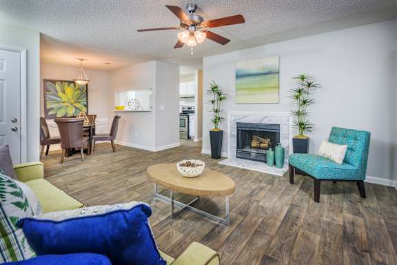 A living room with a fireplace and a blue chair at The Pointe at Irving Park, Greensboro, NC, 27408