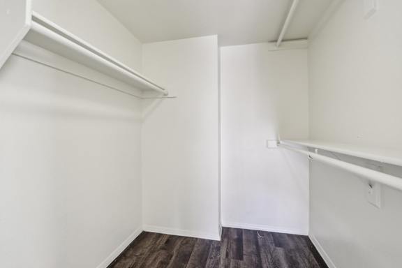 A white room with a wooden floor and a white door.