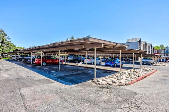 A parking lot with a building in the background and cars parked in the lot.