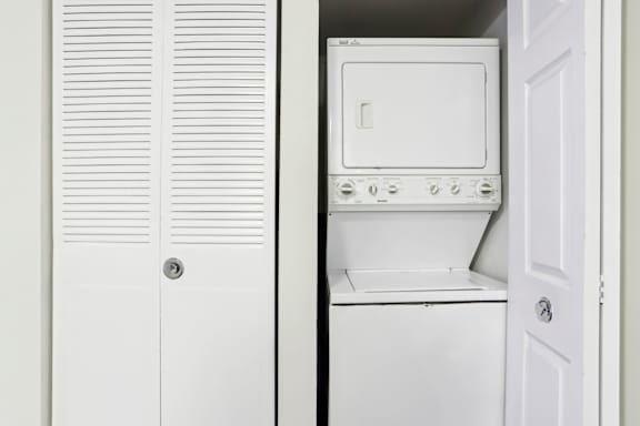 A white oven and microwave are installed in a kitchen. at Millennium at Creve Coeur, Missouri, 63141