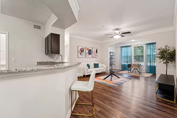 A modern kitchen with a bar stool and a white chair.