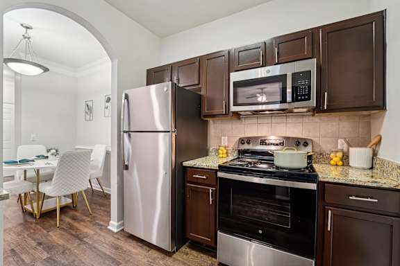 A kitchen with a stove, oven, refrigerator, and microwave.