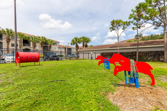 a playground with a red dog and a blue dog on a grassy field at Heritage Bay, Jensen Beach, FL