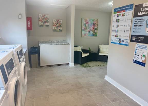 A laundry room with a washer and dryer, a bench, and a bulletin board.