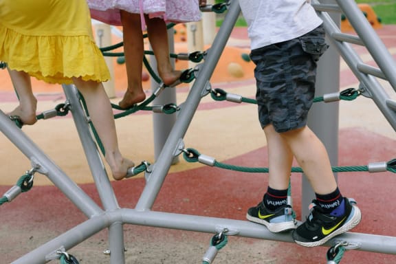 Group of children standing on playground equipment at Glen at Burnsville, Minnesota