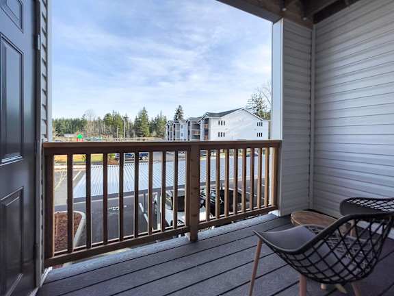 a balcony at Pottery Creek with a view of a lake and a deck with chairs