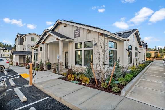 A modern building with a parking lot in front.
