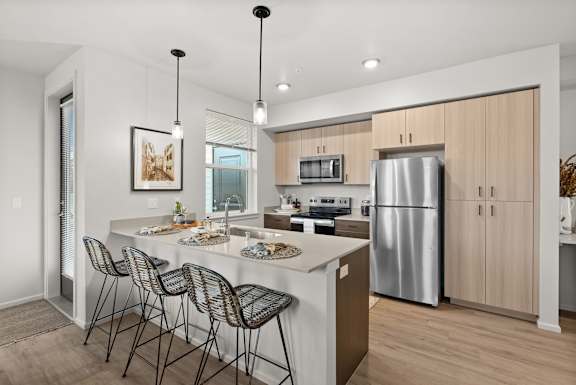 A modern kitchen with a large island and stainless steel appliances.