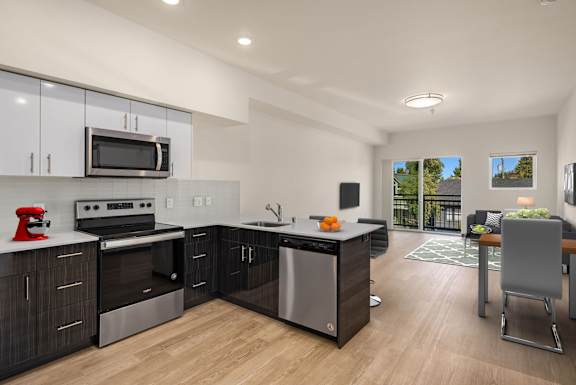 A modern kitchen with stainless steel appliances and wooden floors.