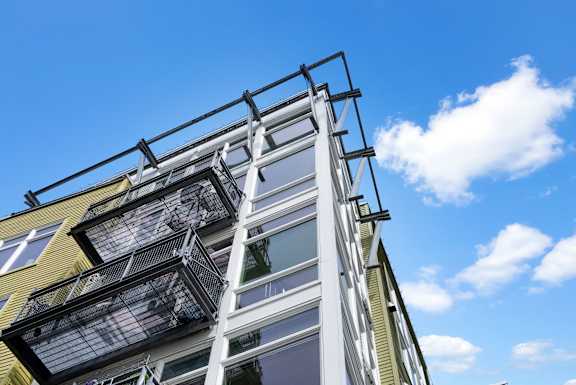 A modern building with a balcony and a metal railing.