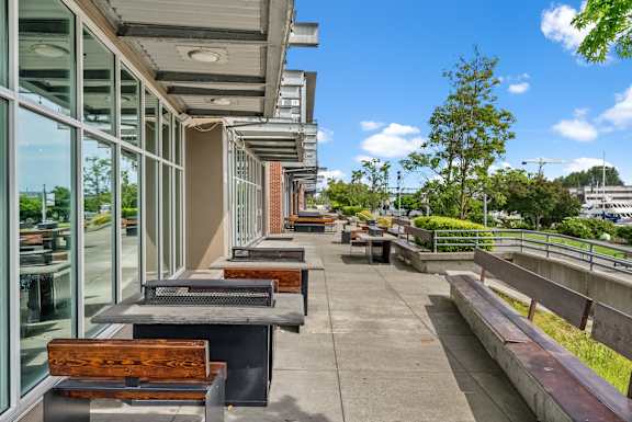 A long row of benches are lined up on a concrete walkway.