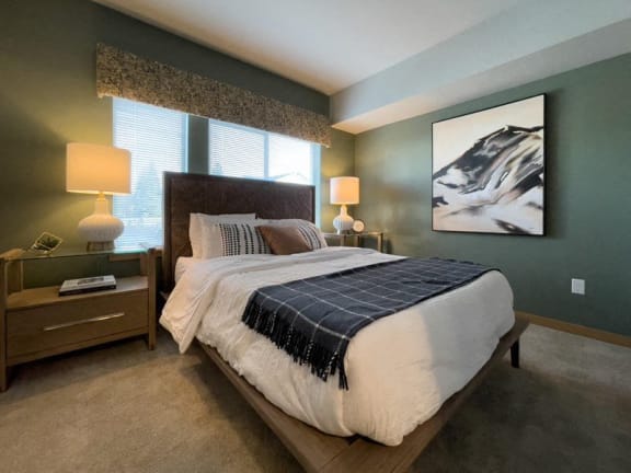 a bedroom with a bed and a painting on the wall at Pottery Creek Apartments, Port Orchard, WA