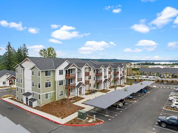 A large apartment complex with a parking lot in front.