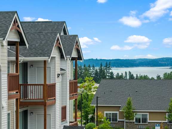 A row of houses with balconies overlooking a lake.