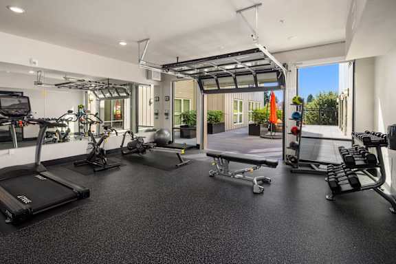A spacious gym with treadmills, exercise bikes, and other equipment.