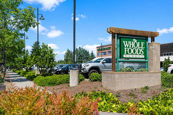 A Whole Foods sign is in front of a parking lot.
